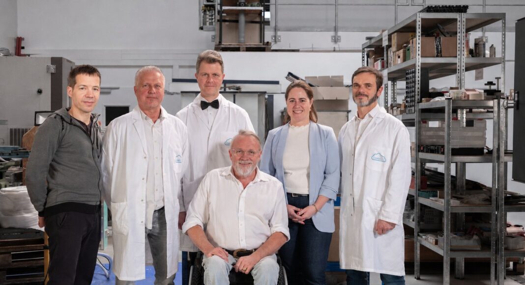 Das Team von HEIONTEC steht in einer Werkhalle, einer der Gründer sitzt im Rolls