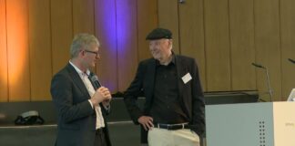 Helmut Schönenberger und Günter Faltin stehen im Gespräch auf der Bühne im Audimax der FU Berlin beim Entrepreneurship Summit 2026