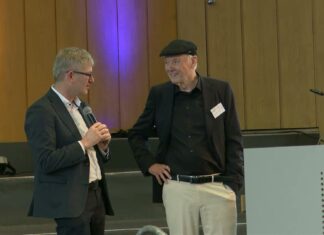 Helmut Schönenberger und Günter Faltin stehen im Gespräch auf der Bühne im Audimax der FU Berlin beim Entrepreneurship Summit 2026