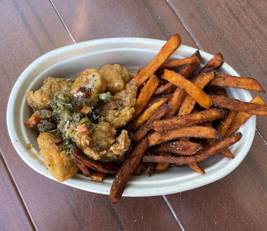 Frittiertes Haehnchen mit Hot Honey und Suesskartoffelpommes auf einem Teller