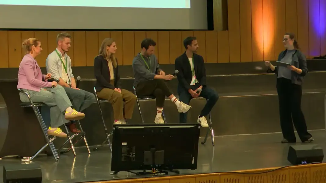 Das Panel Klimaschutz als Geschäftsmodell auf der Bühne des Audimax, rechts die Moderatorin