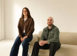 Die Kuro-Gründer Lea Scherer und Jonas Minkler in einem hellen Raum an einem Sofa
