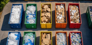 Luftaufnahme eines Wertstoffhofs mit sortierten Containern voller Verpackungen