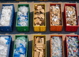 Luftaufnahme eines Wertstoffhofs mit sortierten Containern voller Verpackungen