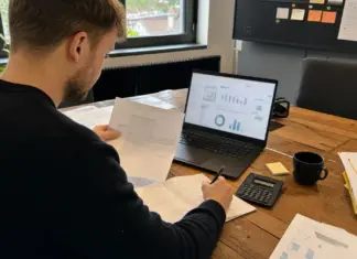Gründer prüft Unterlagen zur stillen Beteiligung am Schreibtisch