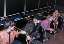 Missoir bei der Höhle der Löwen: Urinal für Frauen, ganz ohne Wasser Fünf Frauen hocken nebeneinander an Missoir-Hockurinalen mit Haltegriffen in einer dunklen Toilettenanlage und lachen