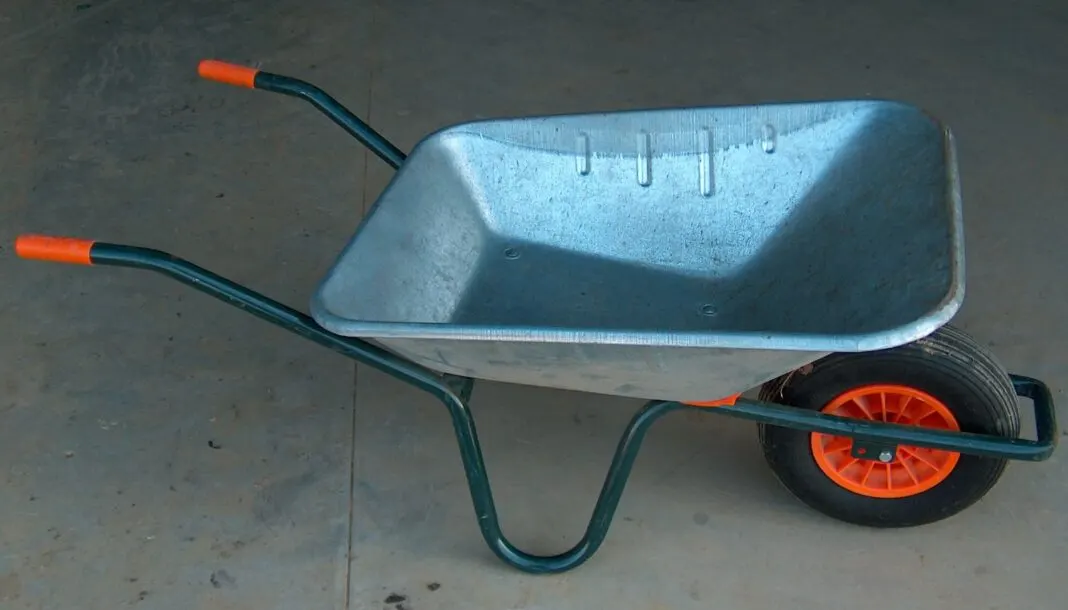 Moderne Schubkarre mit verzinkter Mulde und starren orangefarbenen Griffen