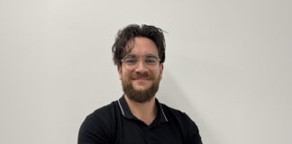 OneCircle-Gründer Baris Mert Colak mit verschränkten Armen vor einer hellen Wand
