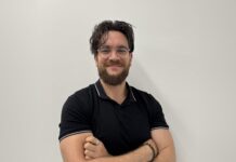OneCircle-Gründer Baris Mert Colak mit verschränkten Armen vor einer hellen Wand
