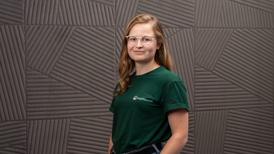 Vivien Dierichsweiler, Gründerin von PetPlanner, im grünen PetPlanner-Shirt vor einer grauen Wand
