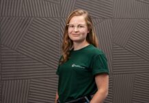 Vivien Dierichsweiler, Gründerin von PetPlanner, im grünen PetPlanner-Shirt vor einer grauen Wand