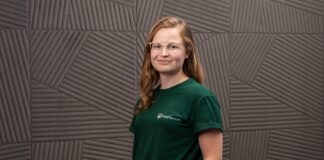 Vivien Dierichsweiler, Gründerin von PetPlanner, im grünen PetPlanner-Shirt vor einer grauen Wand