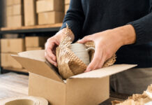 PPWR Online-Shop 2026: Was D2C-Startups bei Eigenmarken und Importen tun müssen Hände verpacken eine Tasse in Graspapier und recycelte Pappe