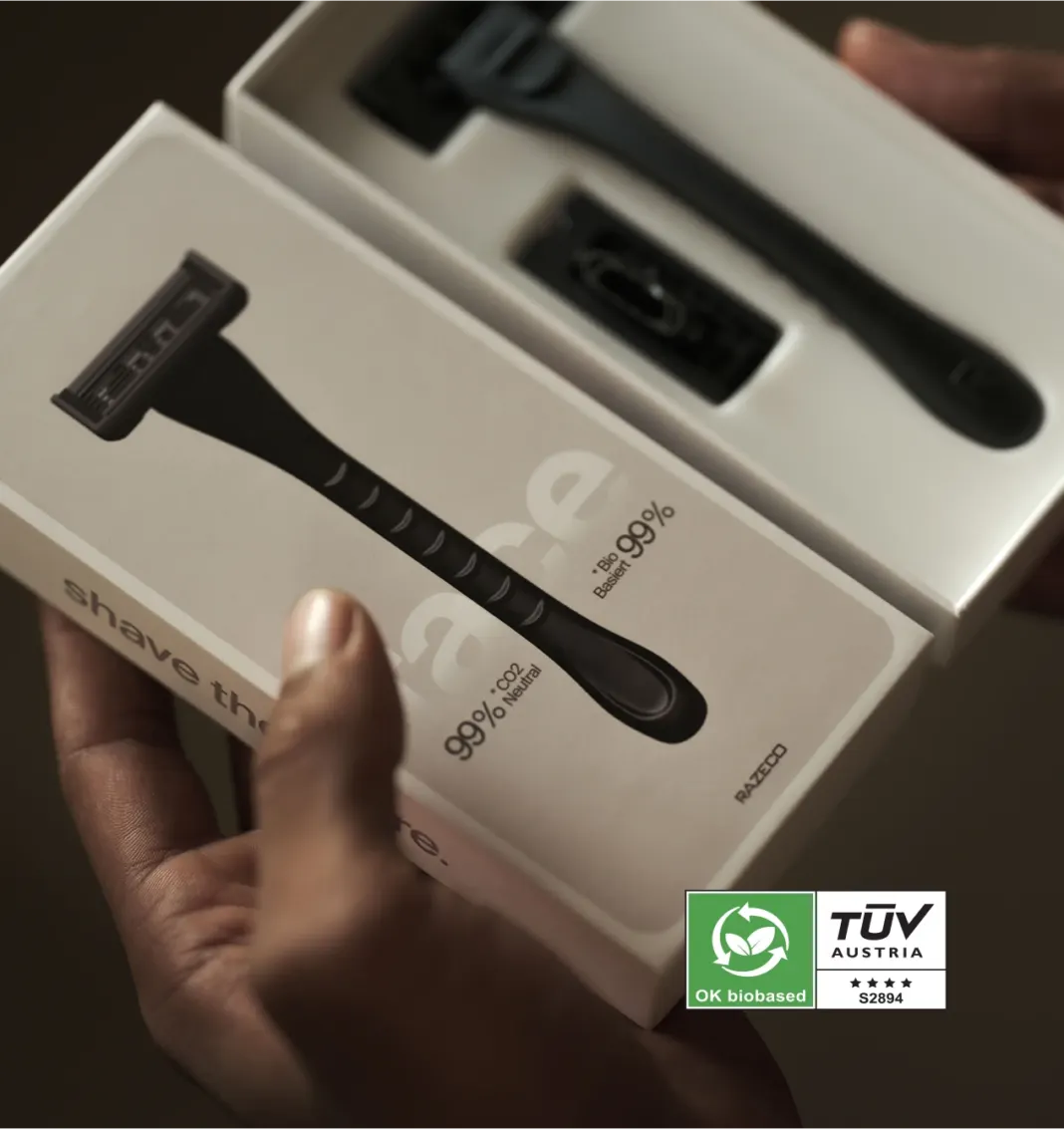 Hände halten eine geöffnete Verpackung mit einem Rasierer, daneben das Siegel OK biobased von TÜV Austria
