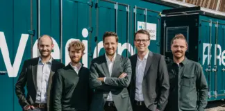 Die fünf Gründer von Reverion stehen vor einem Brennstoffzellenkraftwerk im Container