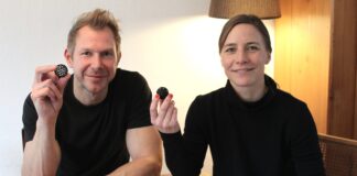 Susanne und Bernd Schmekel, die Erfinder der Sauberkugel, halten an einem Holztisch je eine Sauberkugel in die Kamera