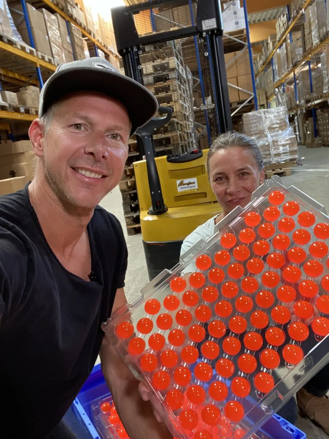 Sauberkugel-Gründer Bernd Schmekel hält im Lager eine Palette mit roten Sauberkugeln