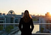 Gründerin blickt bei Sonnenaufgang auf die Reichstagskuppel in Berlin