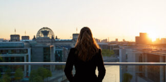 Gründerin blickt bei Sonnenaufgang auf die Reichstagskuppel in Berlin