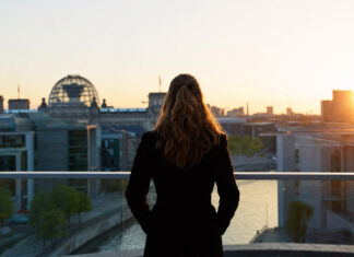 Gründerin blickt bei Sonnenaufgang auf die Reichstagskuppel in Berlin