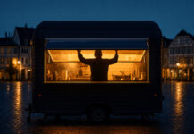 Foodtruck in der blauen Stunde, die Serviceklappe wird von innen geöffnet
