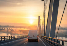 USt-ID beantragen 2026: So klappen erste EU-Rechnungen und Reverse Charge Lieferwagen fährt bei Sonnenaufgang über eine Rheinbrücke nach Frankreich
