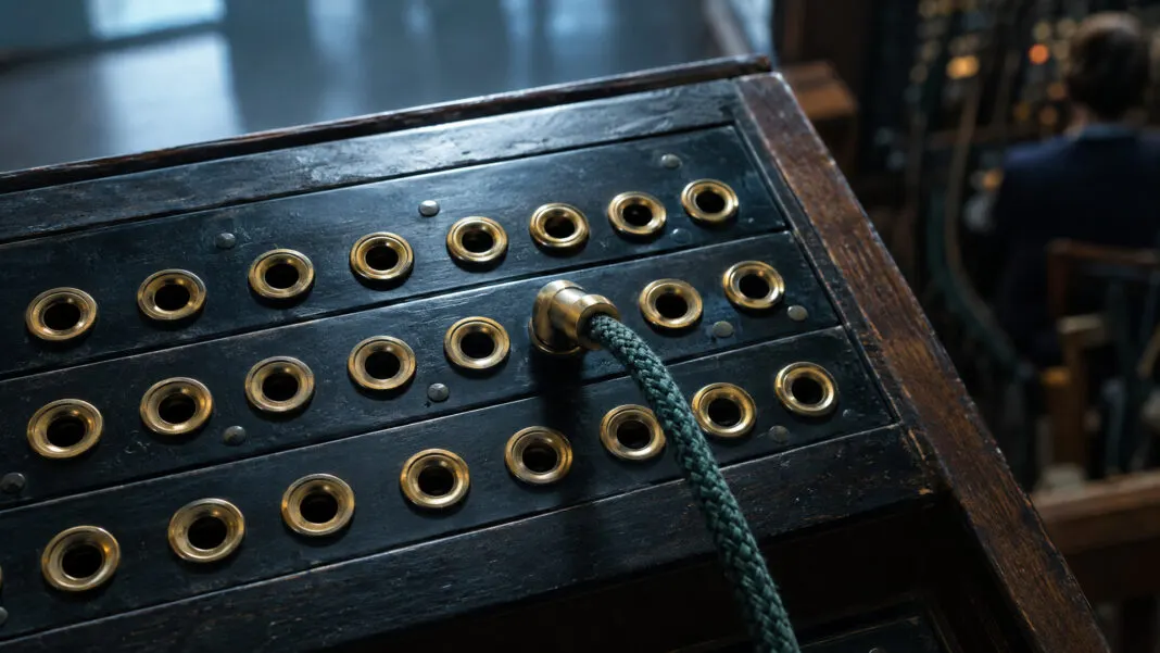 Ein Messing-Steckfeld, in dem ein einzelner Stecker in einer von vielen Buchsen sitzt
