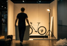 Messeprogramm Young Innovators 2026: Wann sich die BAFA-Förderung lohnt Gründer baut am Abend seinen kleinen Messestand mit E-Bike-Prototyp auf